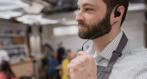 Communicatie en taalvereisten internationale horeca – medewerker met oortje communiceert op de werkvloer